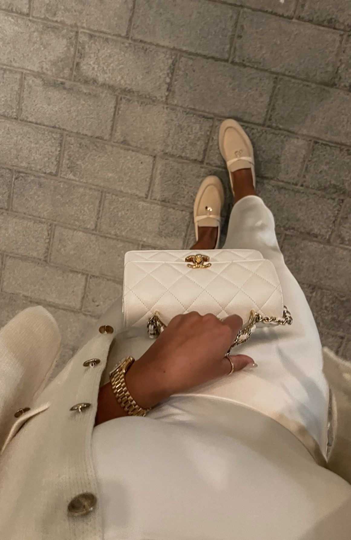 Vit outfit med Chanel-väska och guldklocka