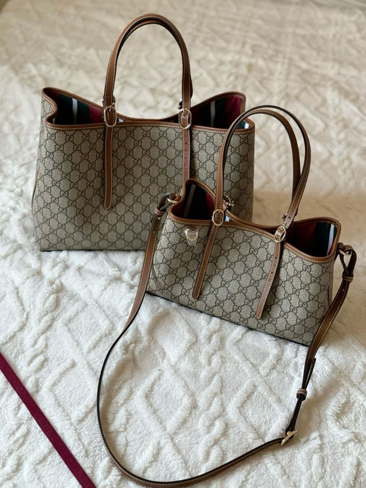 Två Gucci GG-totebags på vitt tyg
